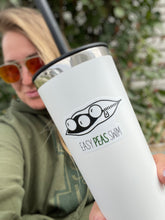 Load image into Gallery viewer, woman in olive green hoodie wearing amber aviators in background holding white hydroflask tumbler with easy peas swim vinyl sticker sitting in front of green bush
