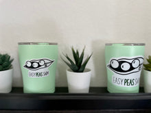 Load image into Gallery viewer, easy peas swim logo on white vinyl sticker on mint green small tumblers on black shelf light grey background next to succulents displaying the two different size options 
