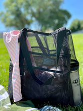 Load image into Gallery viewer, easy peas swim logo black mesh beach bag 20oz hydroflask white tumbler with sticker in green grassy field filled with white muslin blanket and green and pink easy peas swim swimsuits for toddlers pink and white stripes green and white stripes
